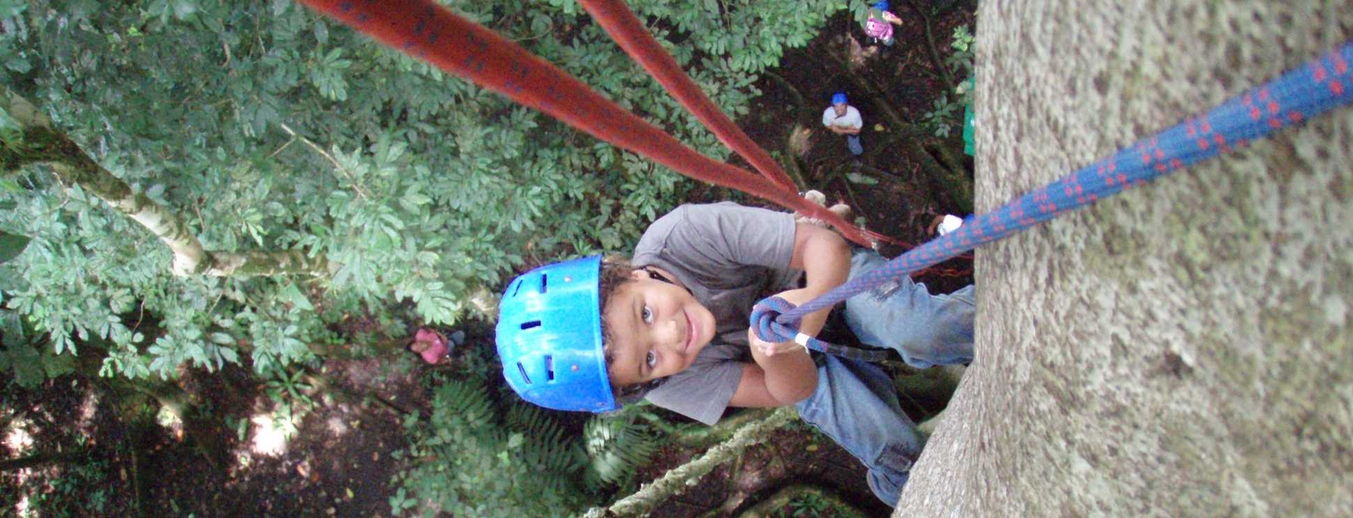 Serendipity Costa Rica guest exiting tree trunk to rappel back to jungle floor